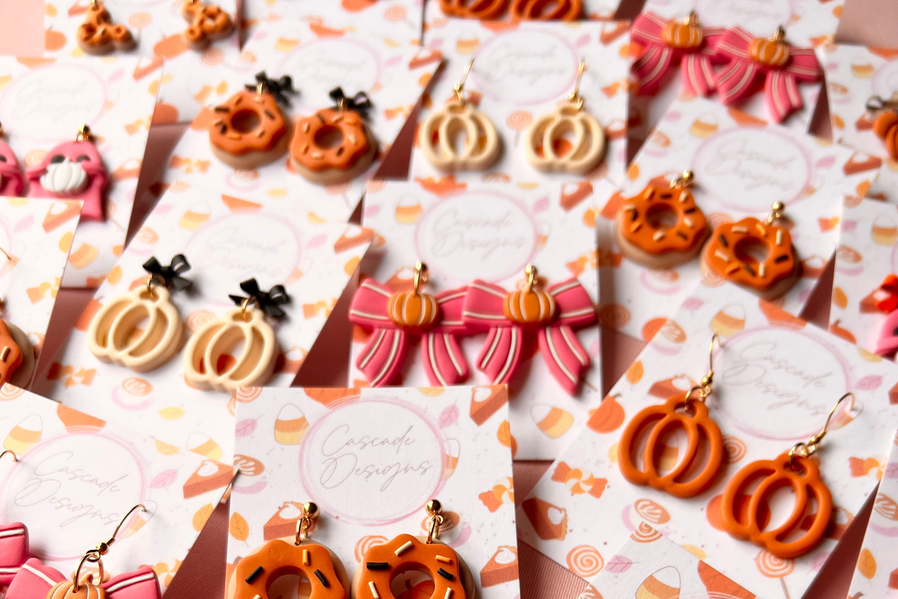 Assorted earrings on branded card holders with a colorful design.